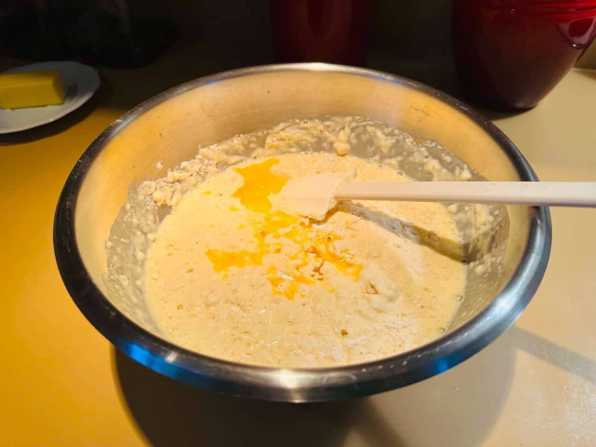 Lumpy batter in steel bowl with white spatula.