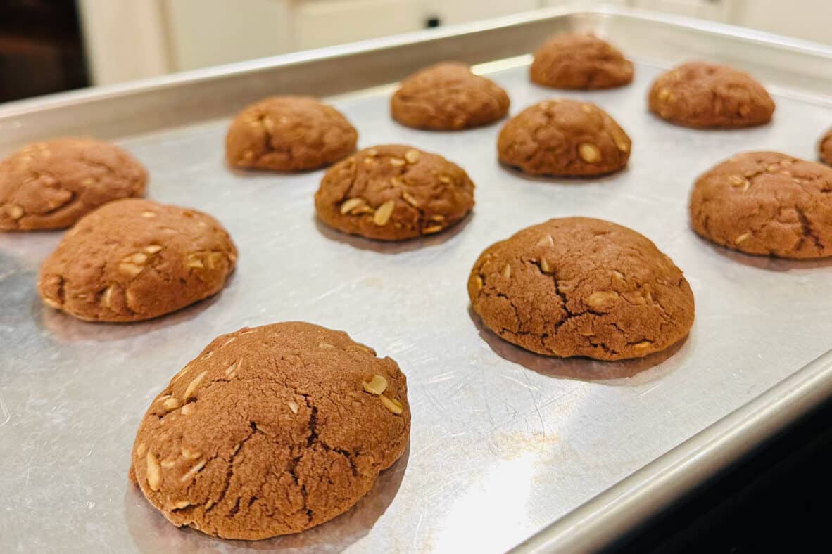 Baked chocolate oatmeal cookies on metal baking sheet.