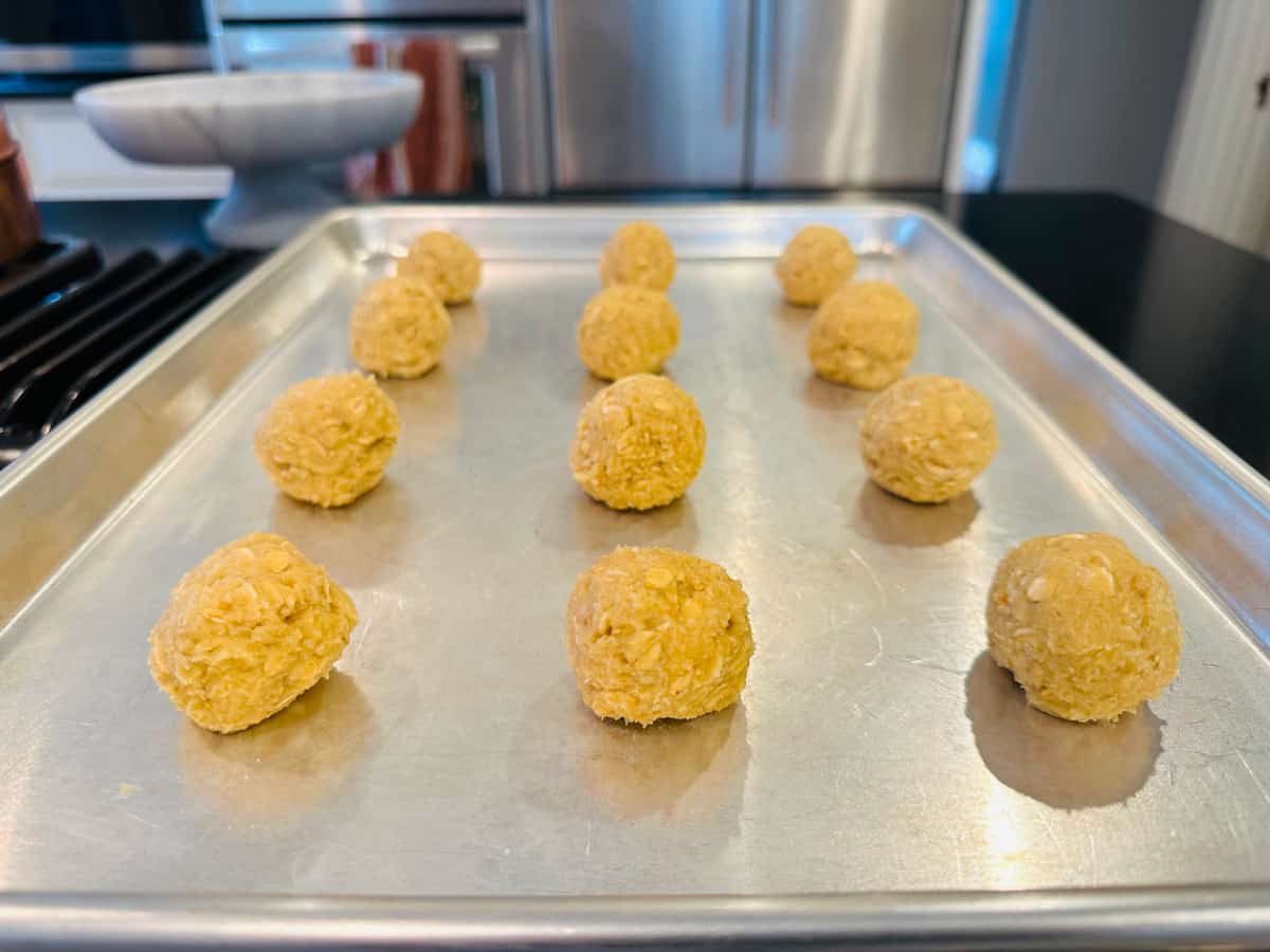 Spheres of cookie dough on a metal baking sheet.