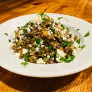 French lentil salad with feta in a white bowl.