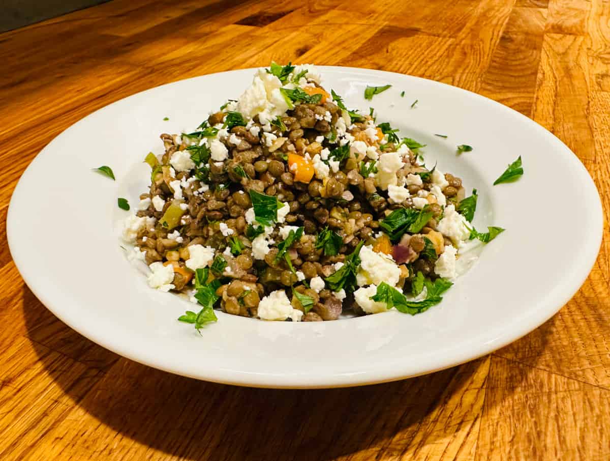 French lentil salad with feta in a white bowl.