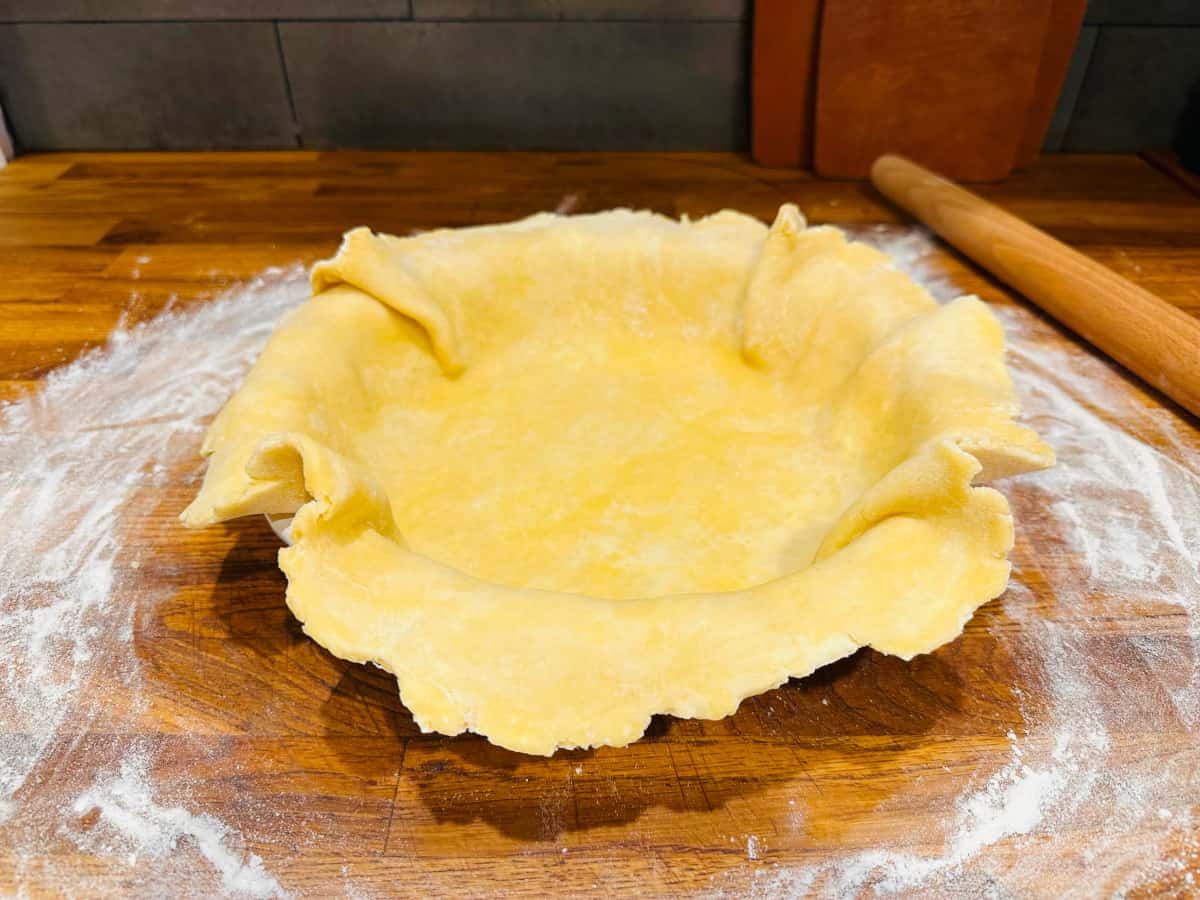 Unbaked pie dough rolled out over a pie plate.