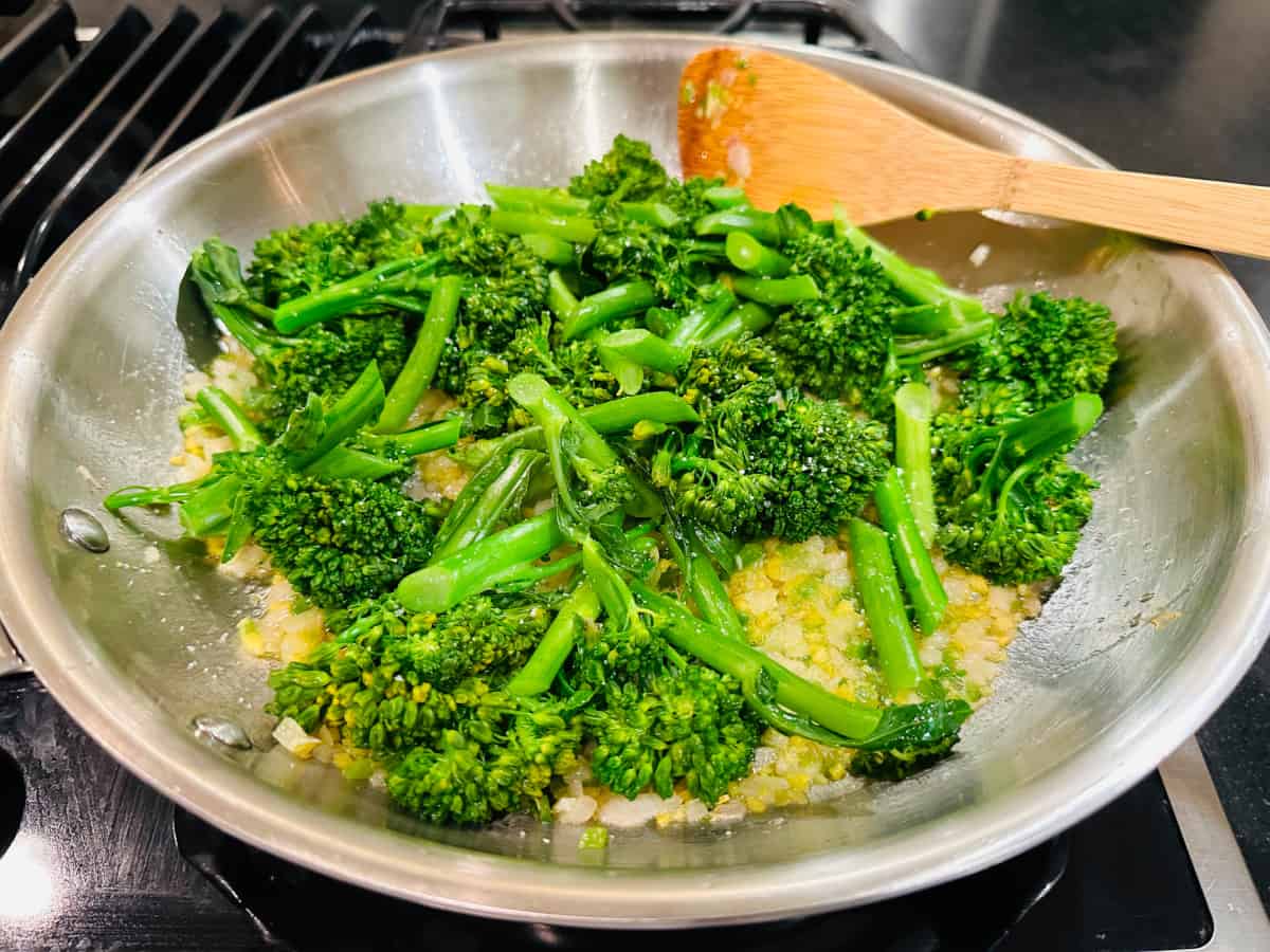 Broccolini pieces with sautéed shallot, ginger, and jalapeño in a large skillet.