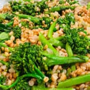 Barley pilaf and broccolini in a skillet.