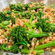 Barley pilaf and broccolini in a skillet.