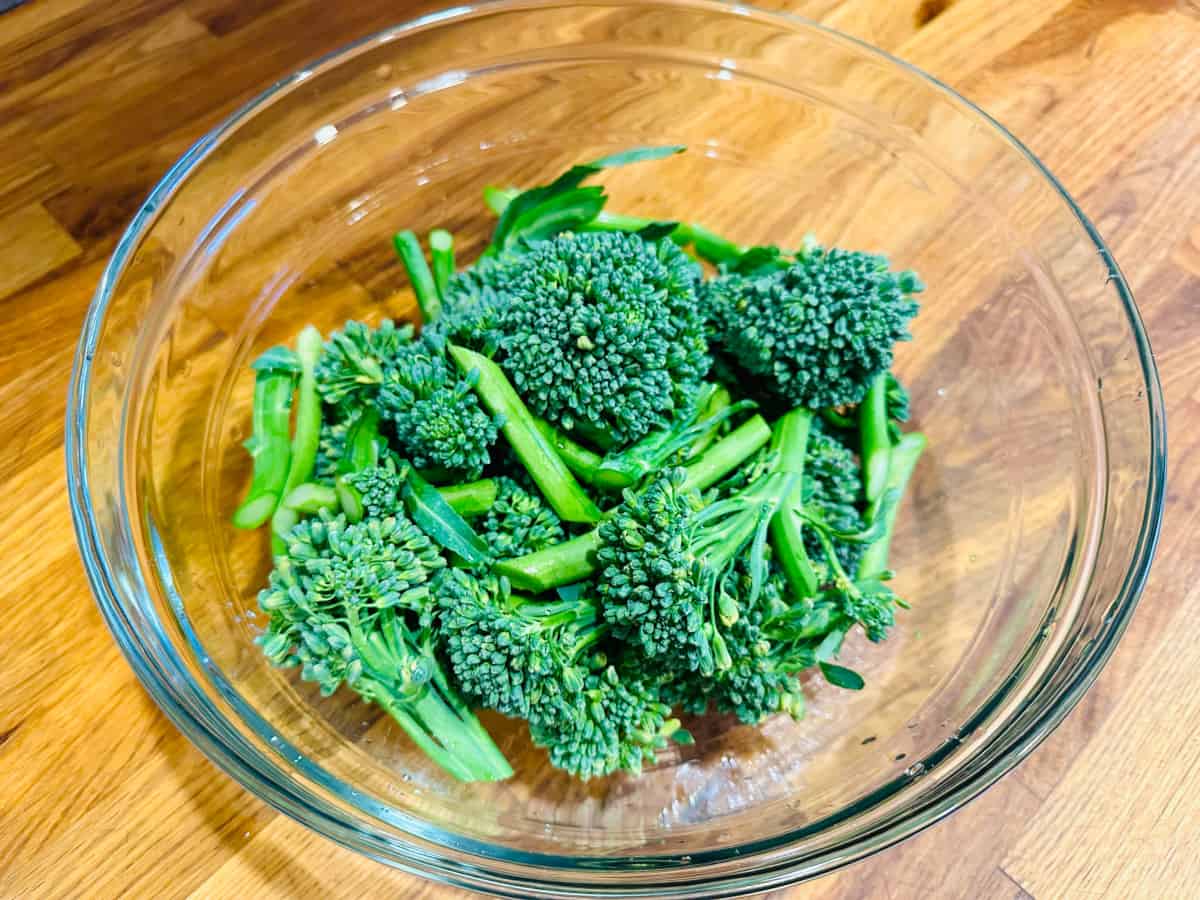 Broccolini pieces in a glass bowl.