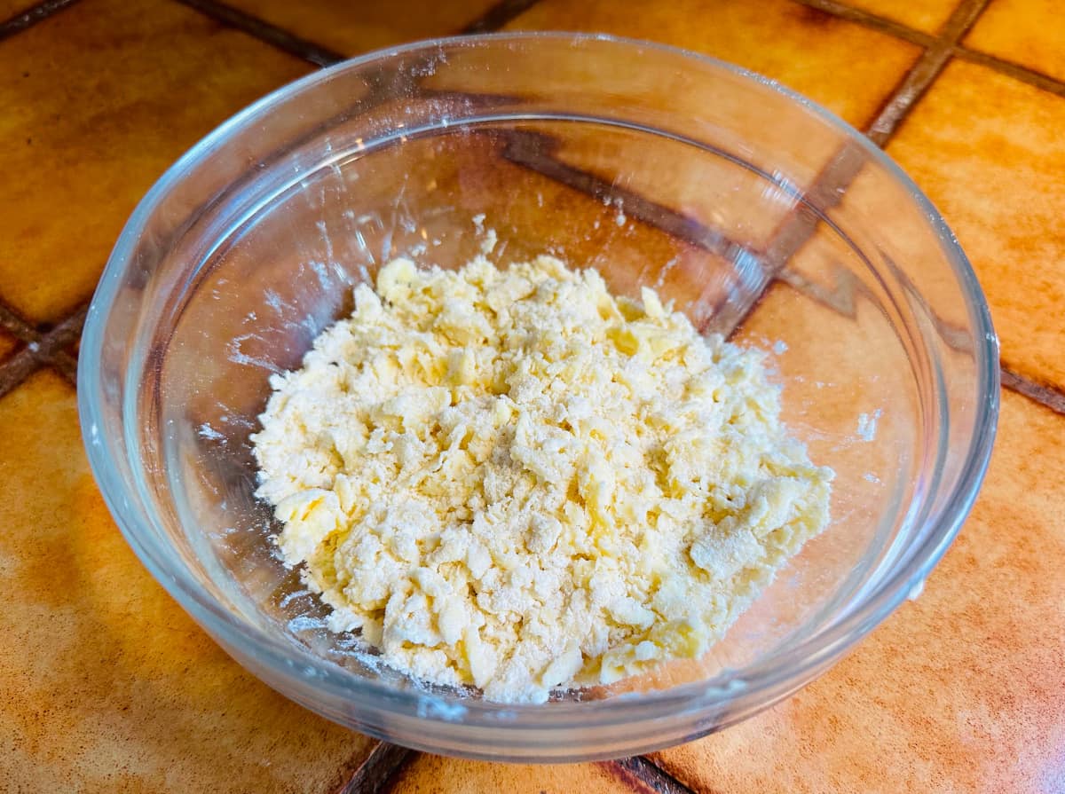 Small clumps of butter and flour in a glass bowl.