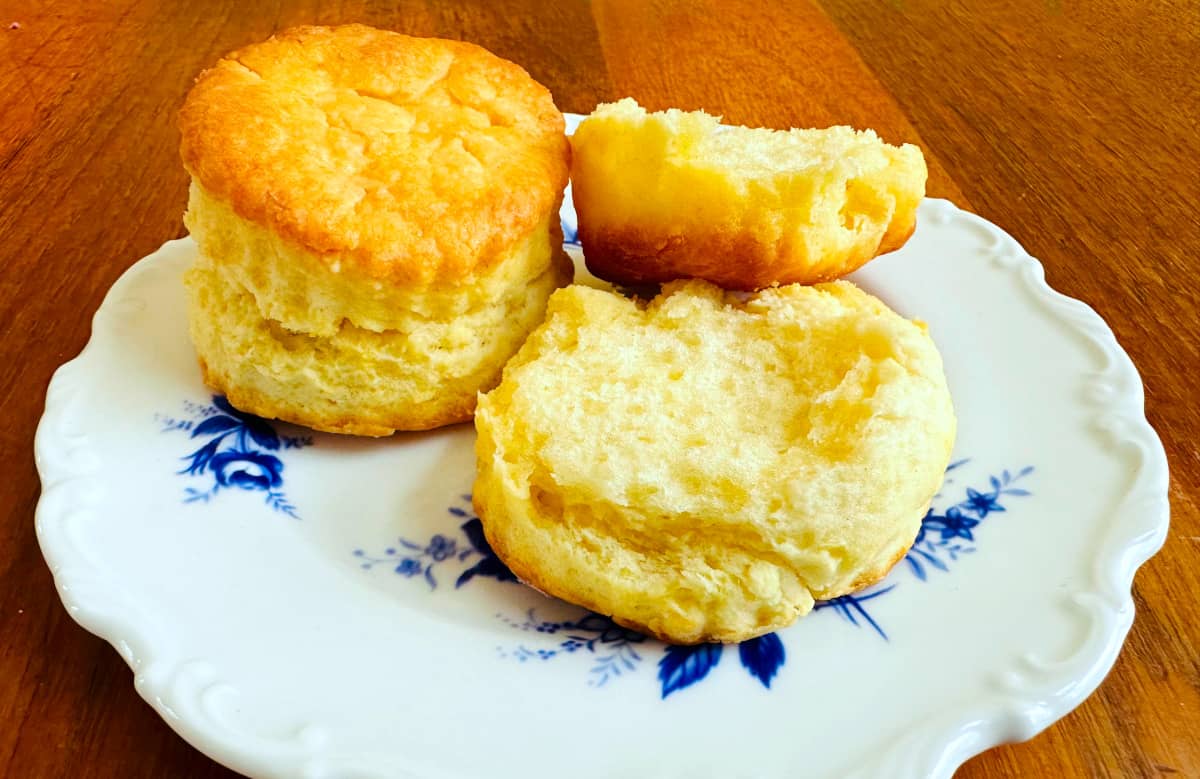 Cream biscuits served on a white plate with blue flowers.