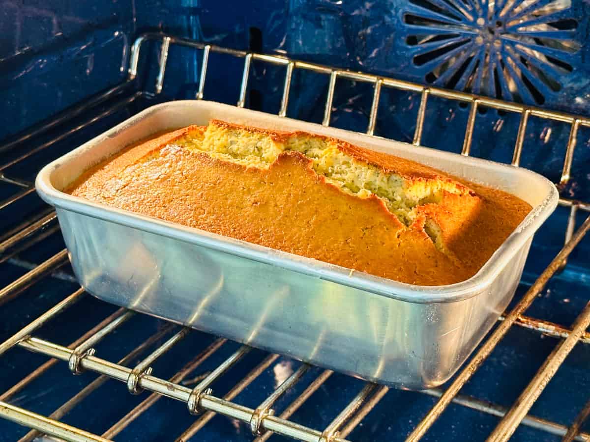 Lemon poppy seed cake baking in a blue oven.