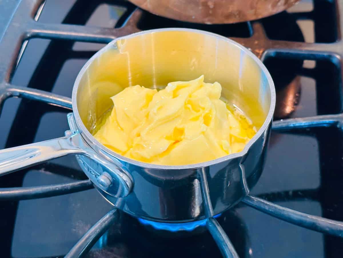 Butter melting in a tiny steel saucepan on the stove.