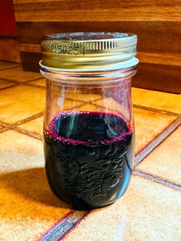 Blueberry simple syrup in a small bottle.
