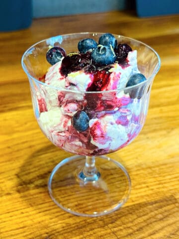 Blueberry fool served in a coupe glass.