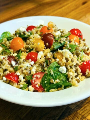 Mediterranean couscous and lentil salad served in a shallow white bowl.