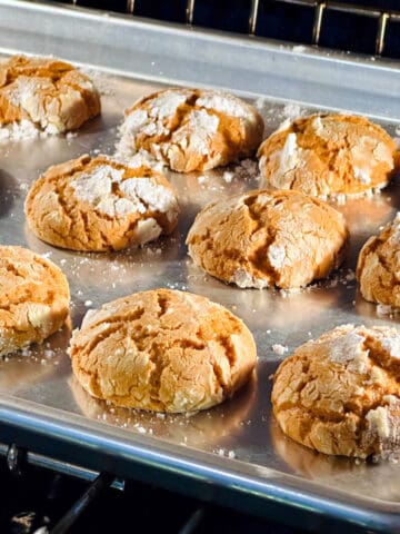 Molasses crinkle cookies on a metal baking sheet.
