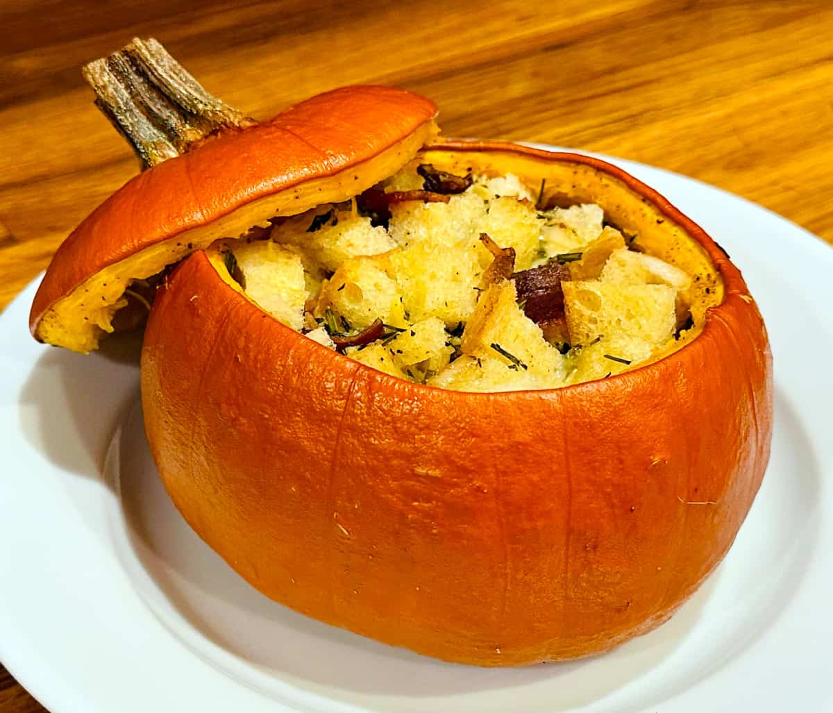 Pumpkin stuffed with everything good served on a white plate.