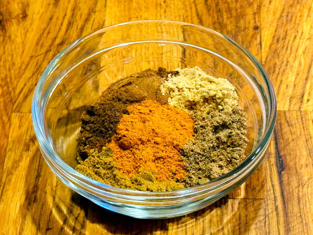 Spices measured out into a small glass bowl.