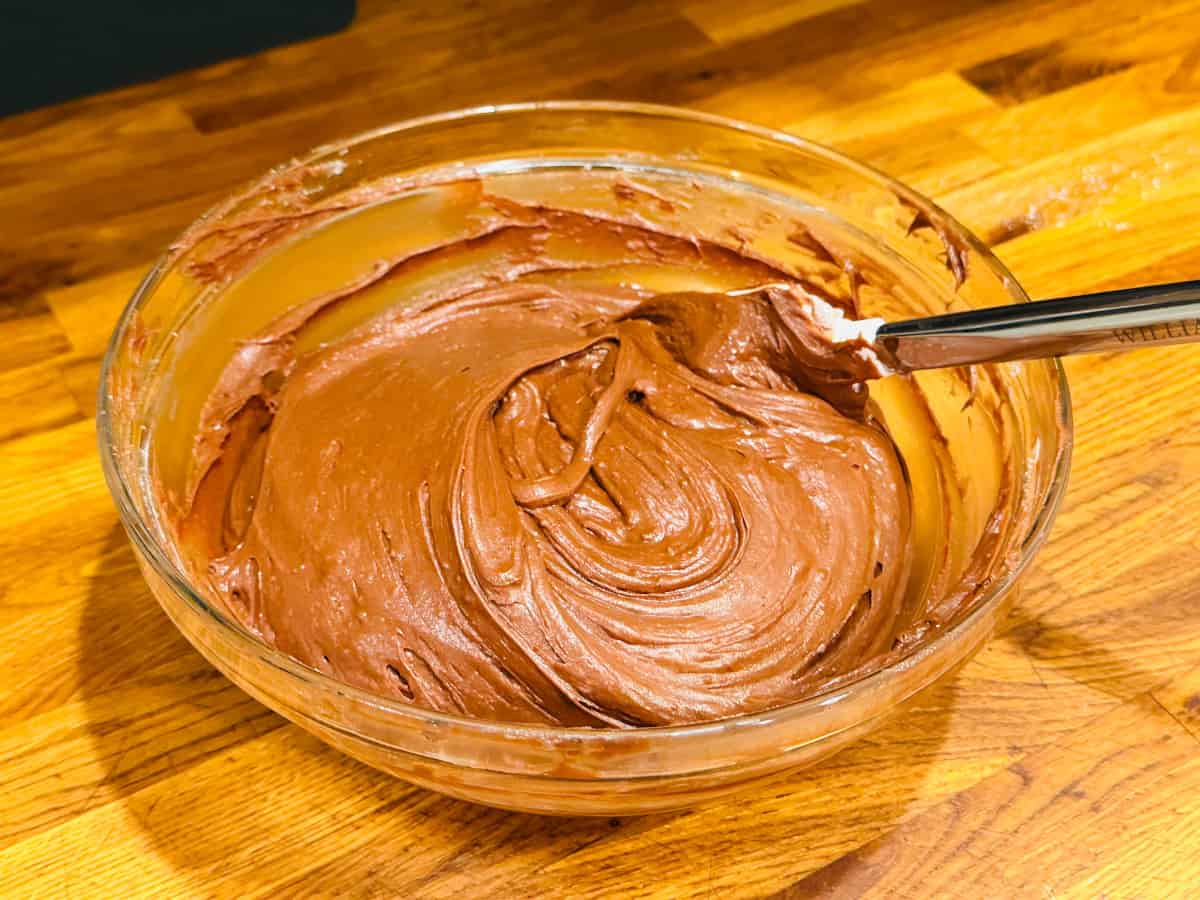Chocolate batter in a glass bowl with a silicone spatula.