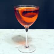 Nordic Negroni in a coupe glass with an orange twist.