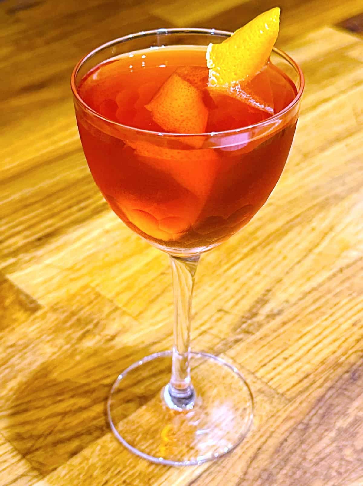 Nordic Negroni in a coupe glass with an orange twist.
