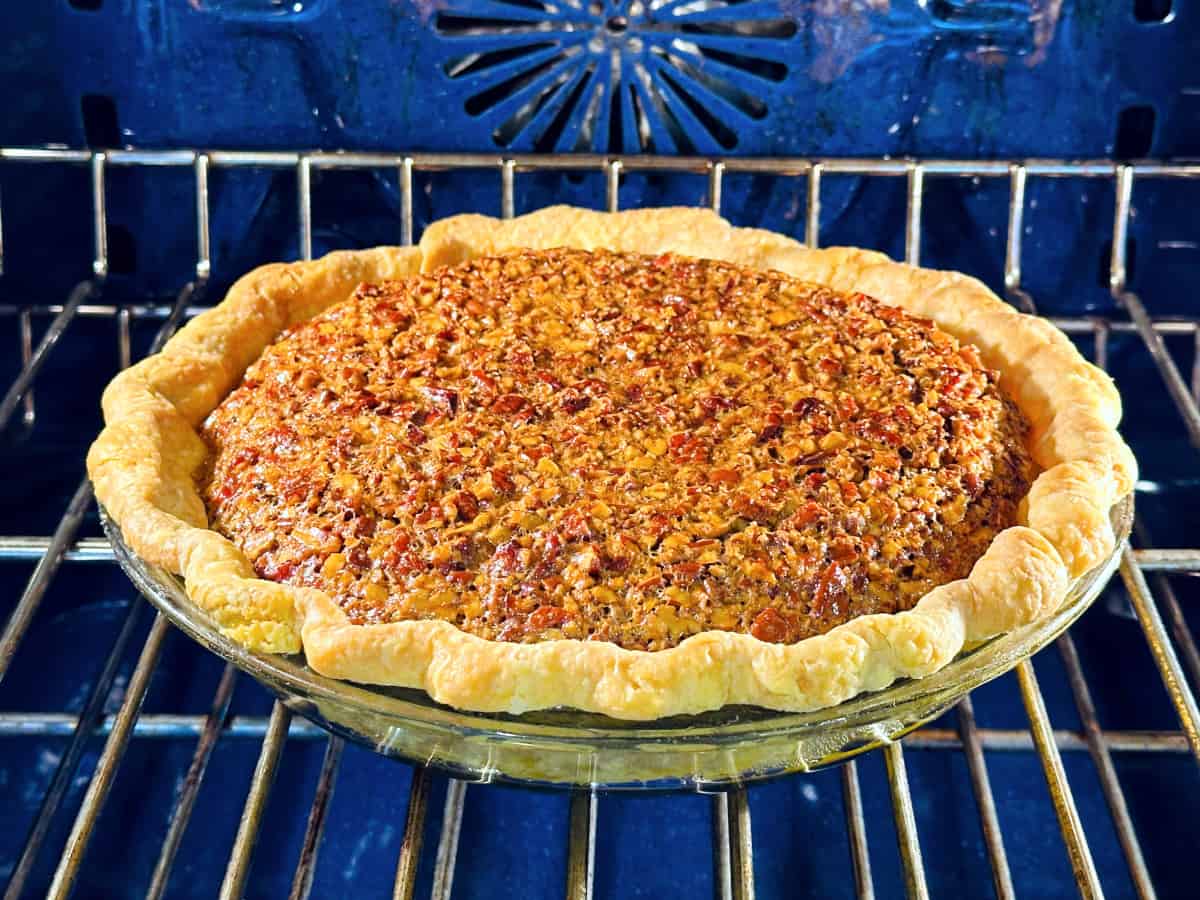 Maple pecan pie baking in a blue oven.