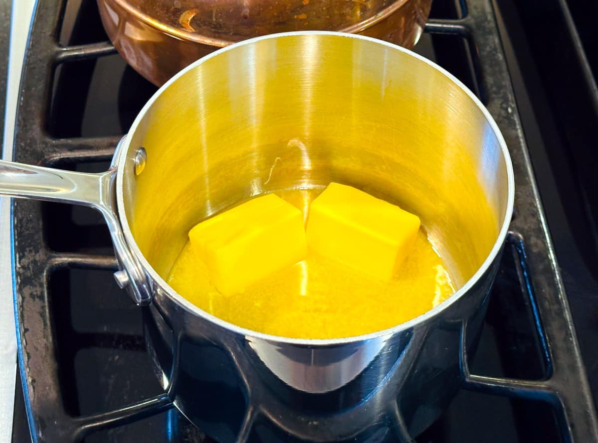 Butter melting in a steel saucepan on the stove.