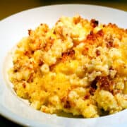 Homemade macaroni and cheese in a shallow white bowl.
