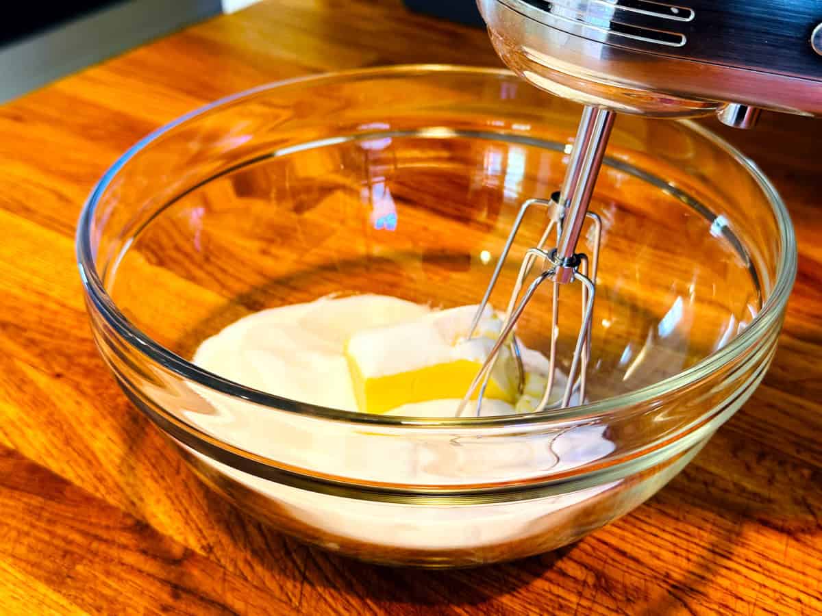 Butter and sugar in a glass bowl with an electric mixer poised to begin beating.