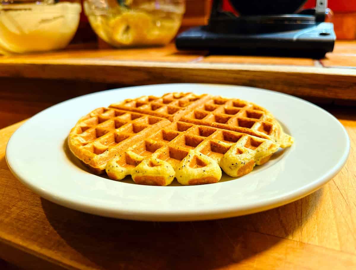 Lemon poppy seed waffle on a white plate.