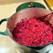 German red cabbage in a dark green dutch oven on the stove.