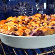 Blueberry bread pudding in a white baking dish sitting in a blue oven.