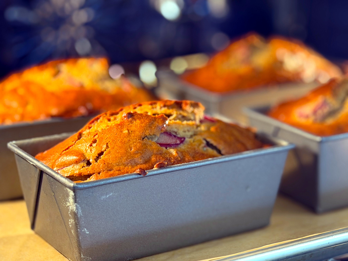 Miniature loaves of rhubarb bread baking in a blue oven.