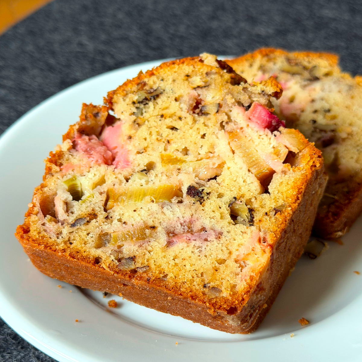 Two slices of rhubarb bread on a small white plate.