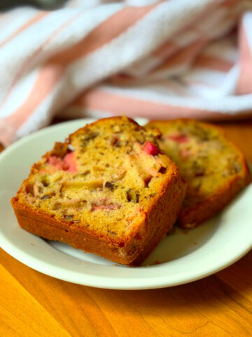 Two slices of rhubarb bread on a small white plate.